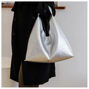 Detail view of shiny silver PU leather tote bag with metallic texture and crinkled finish