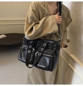 Detail of black PU leather crossbody bag with metal eyelets, chains and multi-pockets