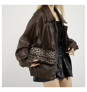 Detail of trendy leopard print underarm bag paired with a brown oversized faux leather jacket