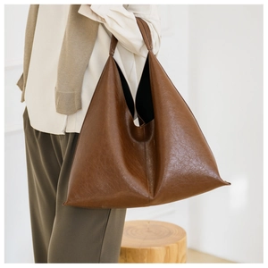 Close-up of vintage brown PU leather shoulder bag with minimalist triangle structure