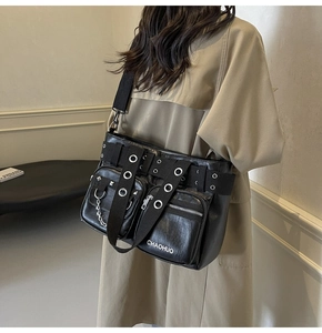 Detail of black PU leather shoulder bag with metal grommets, chains and Chahuo logo
