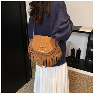 Detail of brown faux suede shoulder bag featuring long fringe and metal ring buckle closure