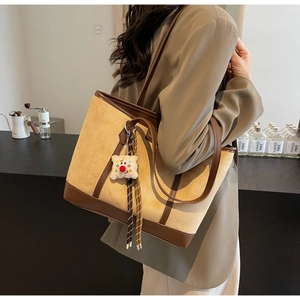 Fashionable beige suede tote bag with brown leather straps and cute plush charm detail