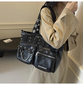 Detail of black PU leather shoulder bag featuring punk metal chains and studs