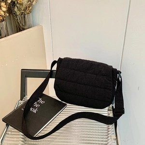 Minimalist black quilted nylon crossbody bag for women with adjustable strap and fluffy texture
