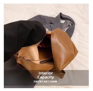 Detailed interior of brown PU leather shoulder bag showing spacious main compartment and zipper pocket