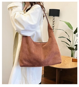 Hobo shoulder bag in caramel suede shown on a model in a minimalist interior