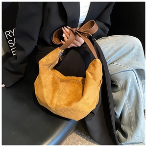 Détail du sac hobo en suédine jaune gingembre avec bandoulière en cuir marron large