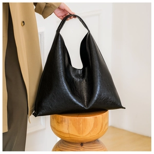 Detail showing high-quality black PU leather texture on a minimalist hobo tote bag