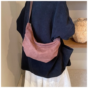 Sac baguette chic en daim rose poudré avec fine bandoulière marron élégante