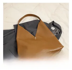 Detailed view of brown PU leather tote bag featuring a unique V-cut opening and gold clasp