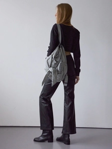 Gray bow-tie cloud bag styled with a minimalist black outfit and leather pants