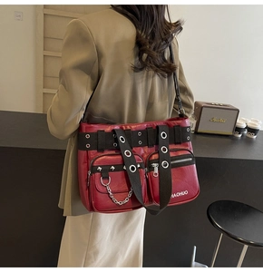 Detail view of burgundy PU crossbody bag with silver punk rivets and heavy metal chains