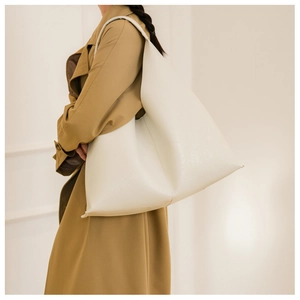 Detailed macro view of white PU leather tote bag with elegant lychee texture and wide strap