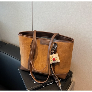 Minimalist caramel suede tote bag with brown leather straps and cute plush bear charm