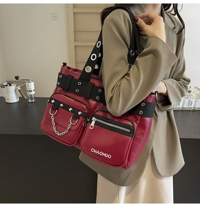 Detail of dark red punk style tote bag with multiple pockets, silver rivets and chains