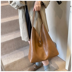 Detail of tan brown vintage PU leather tote bag with soft pleated V-shape design and texture