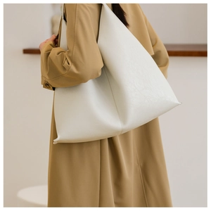 Close-up detail of white PU leather tote bag with lychee grain texture and side pleats