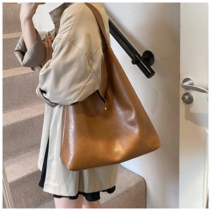 Detailed view of brown PU leather shoulder bag featuring vintage texture and fine stitching