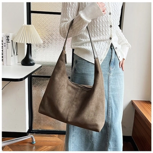 Close-up of brown suede hobo bag showing minimalist design and textured matte finish