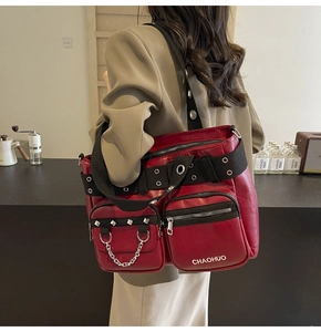 Detail of burgundy PU leather crossbody bag with multiple pockets and silver rivets