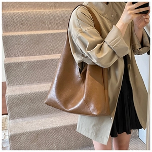 Detailed view of vintage brown PU leather tote bag with smooth texture and metal buckle