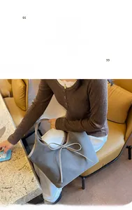 Détail d'un sac cabas gris en daim givré avec nœud minimaliste dans un décor quotidien