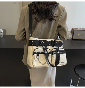 Detail of cream PU leather crossbody bag featuring silver eyelets and metal chain