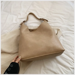 Minimalist beige PU leather tote bag with pleated texture and adjustable wide shoulder strap