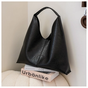 Minimalist black PU leather hobo shoulder bag with wide strap on a soft cream background