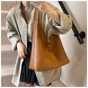 Brown faux leather hobo bag with vintage oil-wax texture shown on a female model
