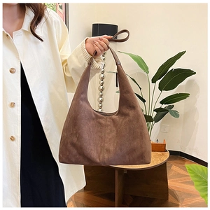 Close-up of matte dark brown PU leather texture on a minimalist hobo shoulder bag