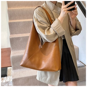 Detailed macro view of retro brown faux leather texture and stitching on tote bag