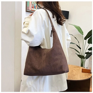 Close-up of brown matte suede tote bag with minimalist shoulder strap detail