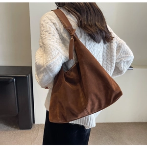 Detail view of deep brown suede hobo bag featuring wide straps and matte texture finish