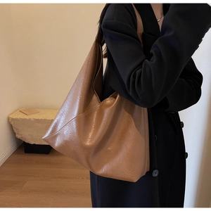 Macro detail of the vintage brown hobo bag showing its soft pleated leather texture