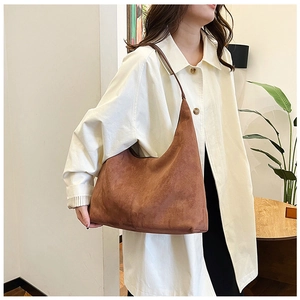 Close-up of brown suede hobo bag with matte texture and minimalist slouchy design