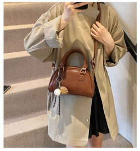 Nahaufnahme der dunkelbraunen PU-Leder-Boston-Tasche mit Baseball-Anhang und Gurt