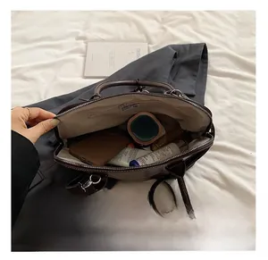 Spacious interior of brown PU shoulder bag with pockets for phone and cosmetics
