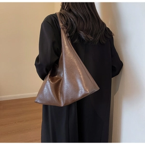 Detailed view of dark brown oversized leather tote bag with vintage wrinkled texture