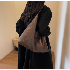 Detail view of large dark brown leather tote bag with soft texture and minimalist design