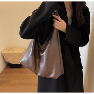 Detail showing high-quality brown oil-wax leather texture on a large hobo bucket bag