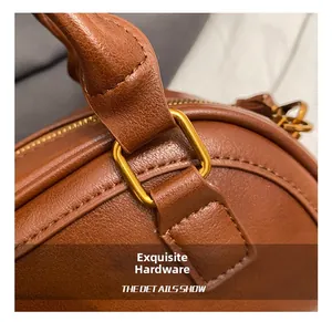 Nahaufnahme der goldenen D-Ring-Hardware und präzisen Nähte der braunen PU-Lederhandtasche