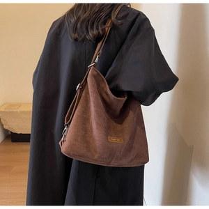 Close-up of a brown suede hobo bag showing the high-quality fabric texture and fashion label