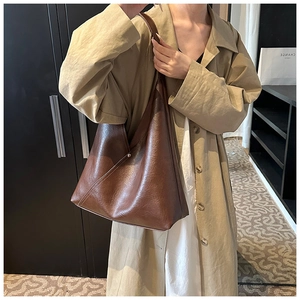 Detail of soft brown PU leather hobo tote showing decorative stitching and metal rivets