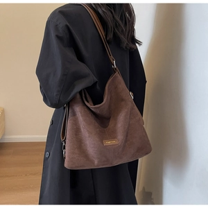 Detail of dark brown faux leather tote bag with FASHION label on a model