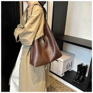 Brown PU leather tote bag with vintage texture shown in a casual lifestyle setting