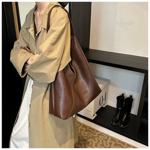 Detail view of deep brown faux leather tote bag showing fine stitching and lychee texture