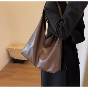 Detailed texture of dark brown faux leather on a large slouchy hobo tote bag