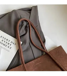 Close-up of brown PU leather tote bag with vintage texture and sleek shoulder straps